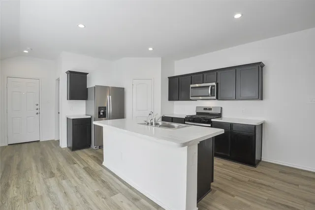 a kitchen with a sink a counter top space stainless steel appliances and cabinets