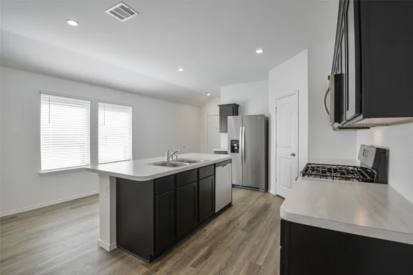 a kitchen with stainless steel appliances granite countertop a sink stove and refrigerator