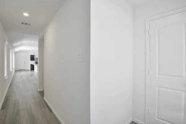 a view of a hallway with wooden floor