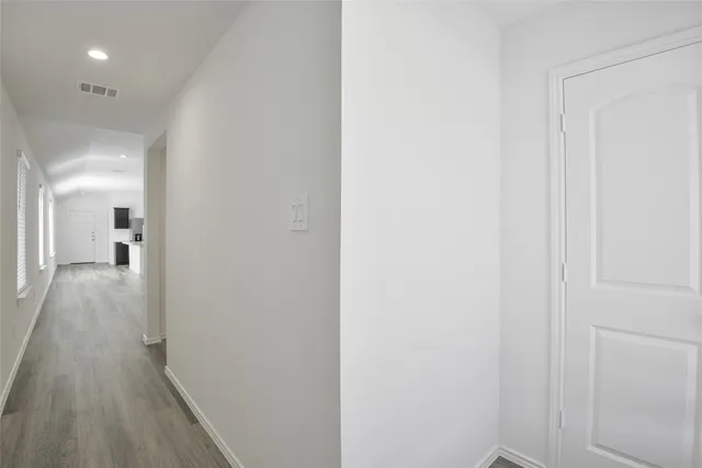 a view of a hallway with wooden floor