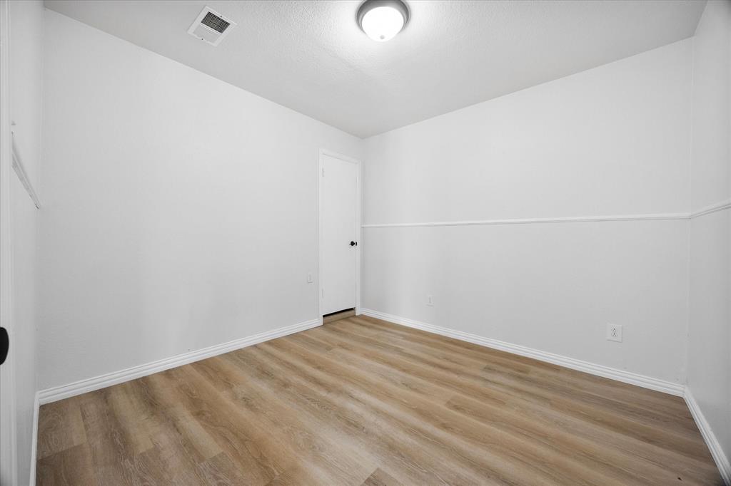925 Lake North Road Rowlett, TX 75089 - Photo 15 of 37 Wood-finish flooring, white walls, and a white interior door