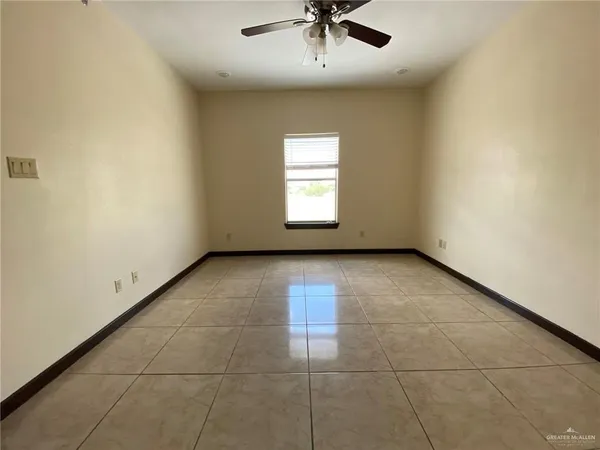 an empty room with a ceiling fan and carpet