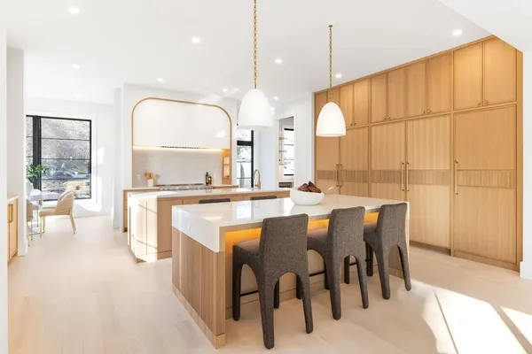 a dining hall with stainless steel appliances kitchen island granite countertop a stove a sink a dining table and chairs