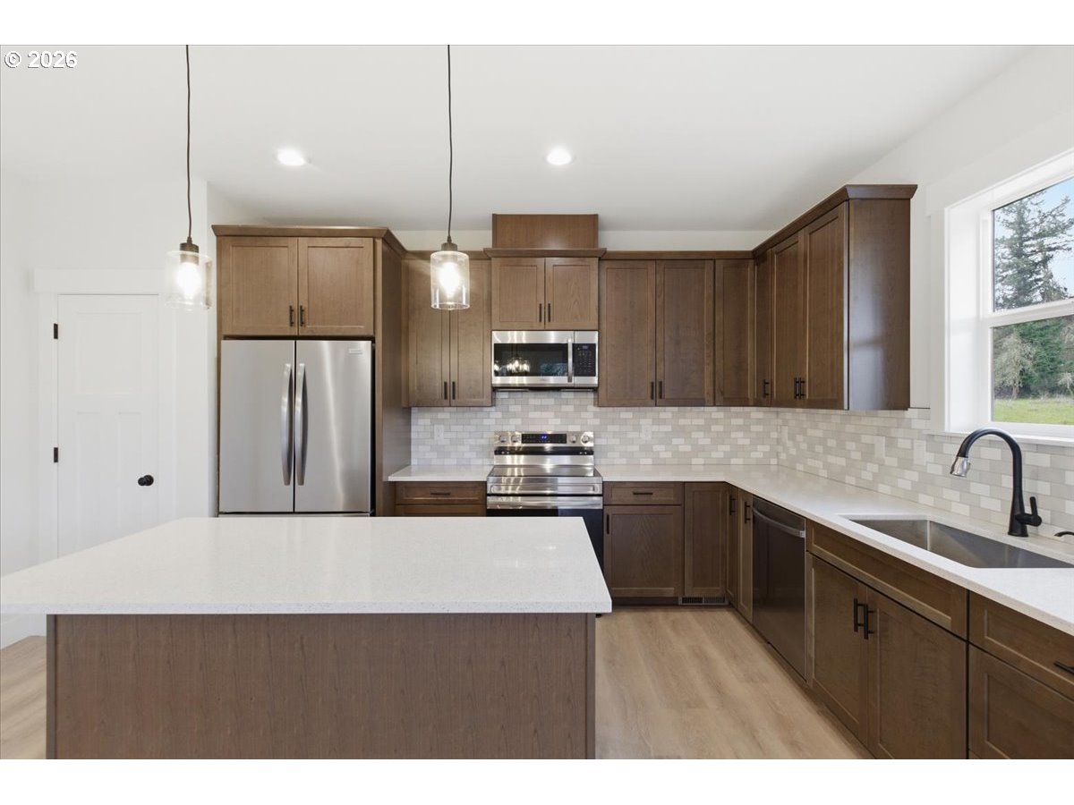 3191 Northwest 23rd Avenue Albany, OR 97321 - Photo 13 of 47 a kitchen with a sink a stove a refrigerator and a microwave