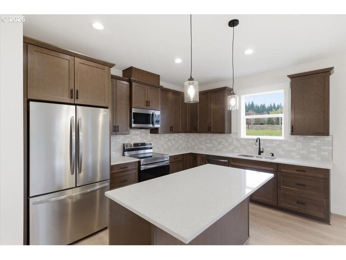3191 Northwest 23rd Avenue Albany, OR 97321 - Photo 14 of 47 a kitchen with kitchen island a sink stainless steel appliances and cabinets