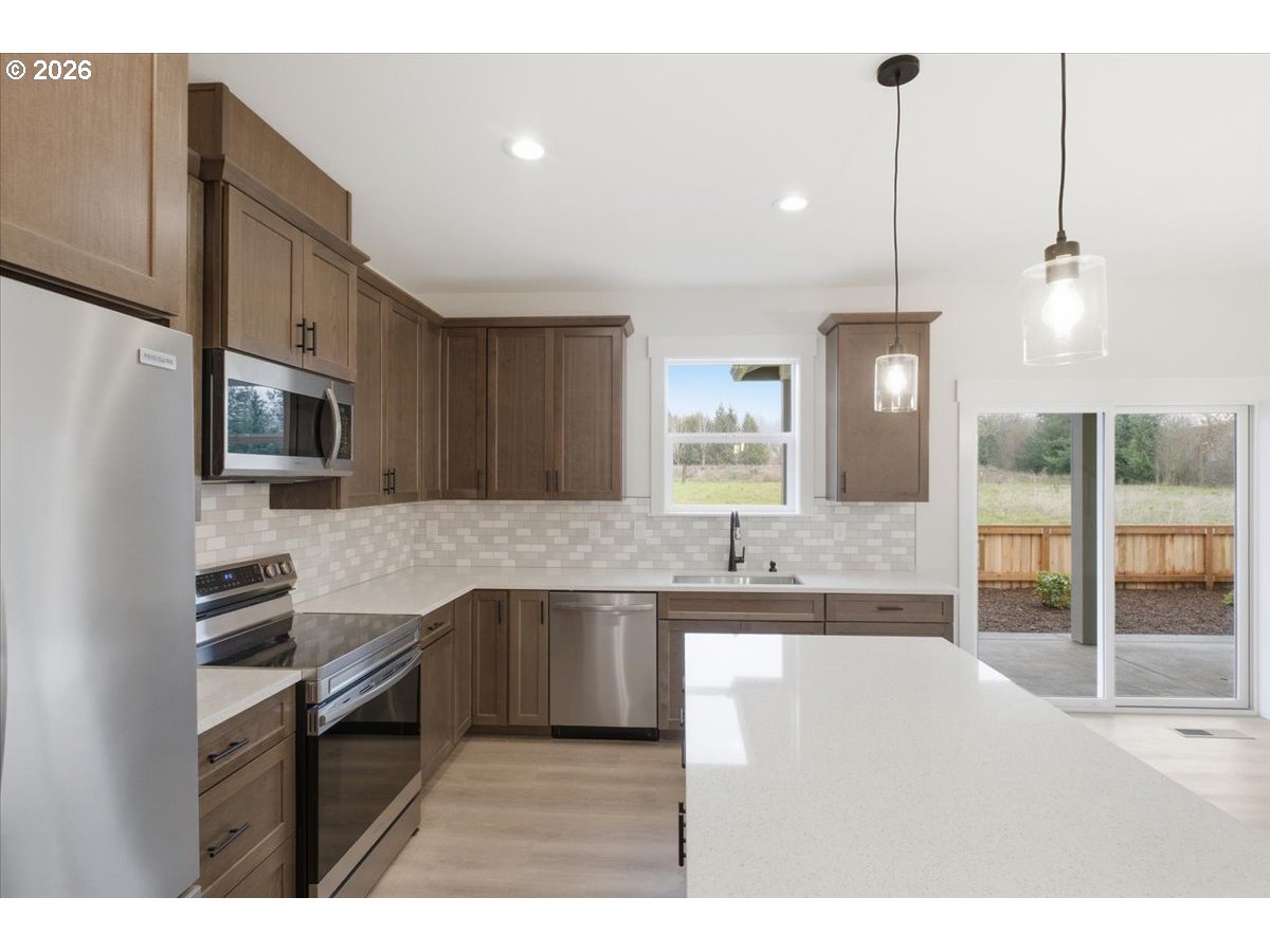 3191 Northwest 23rd Avenue Albany, OR 97321 - Photo 15 of 47 a kitchen with stainless steel appliances granite countertop a sink refrigerator and cabinets