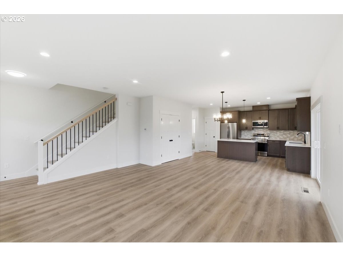 3191 Northwest 23rd Avenue Albany, OR 97321 - Photo 7 of 47 a open kitchen with kitchen island a sink dishwasher a stove and a refrigerator with wooden floor