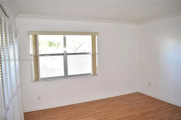 an empty room with wooden floor and a window
