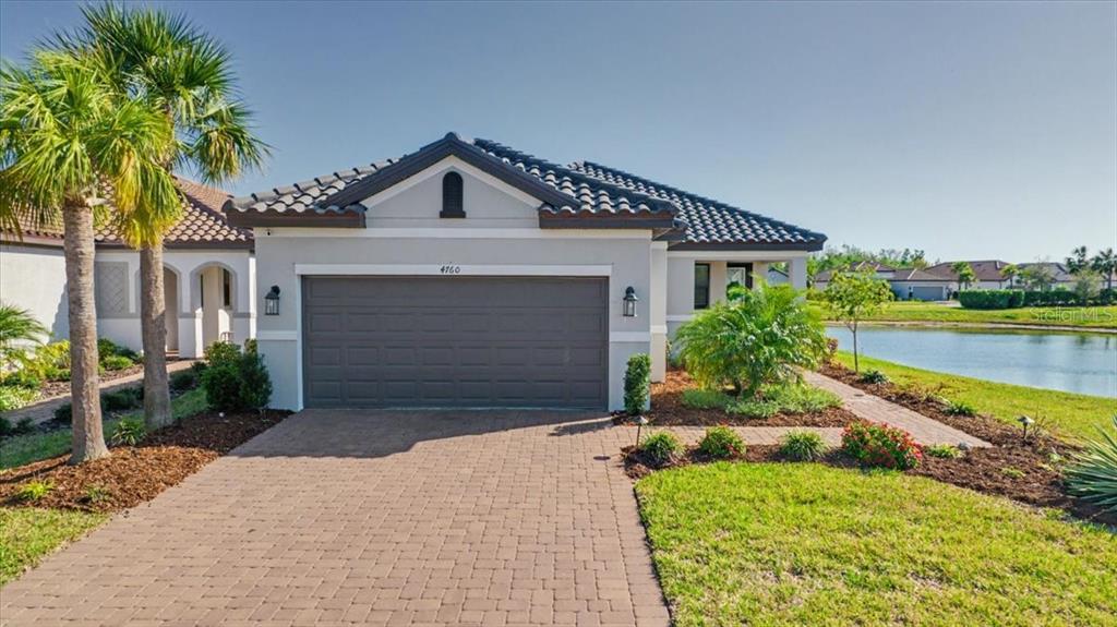 4760 Crestpoint Way Palmetto, FL 34221 - Photo 1 of 44 a front view of a house with a yard and garage