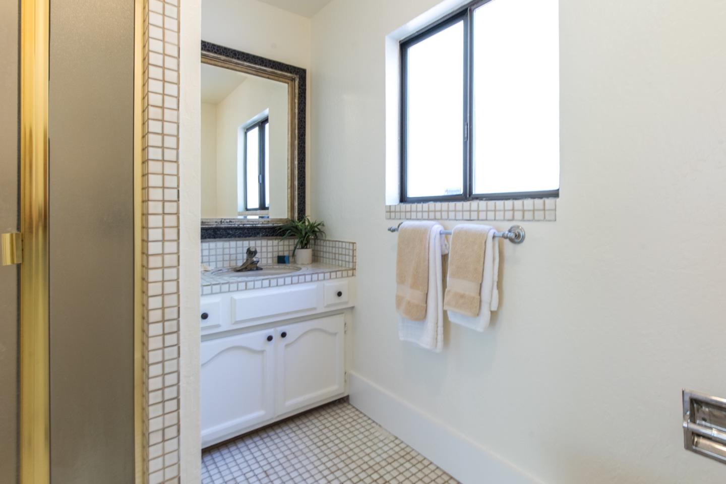 560 Hidden Valley Road Soquel, CA 95073 - Photo 38 of 59 a bathroom with a granite countertop sink a mirror and a window