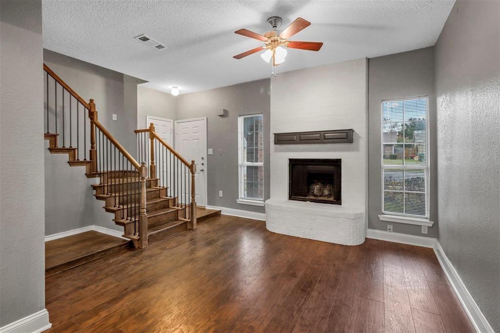 814 Custer Street Arlington, TX 76014 - Photo 3 of 17 a view of an empty room with wooden floor fireplace and a window