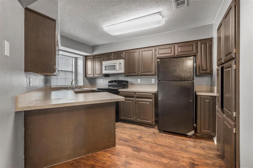 814 Custer Street Arlington, TX 76014 - Photo 5 of 17 a kitchen with kitchen island a counter top space cabinets and stainless steel appliances