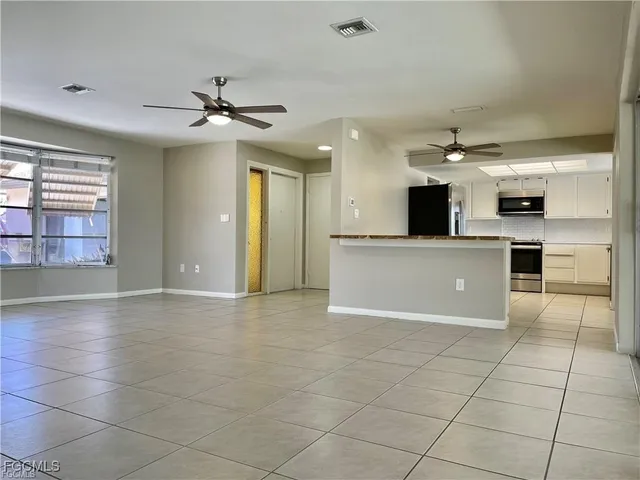 a view of kitchen with cabinets and window