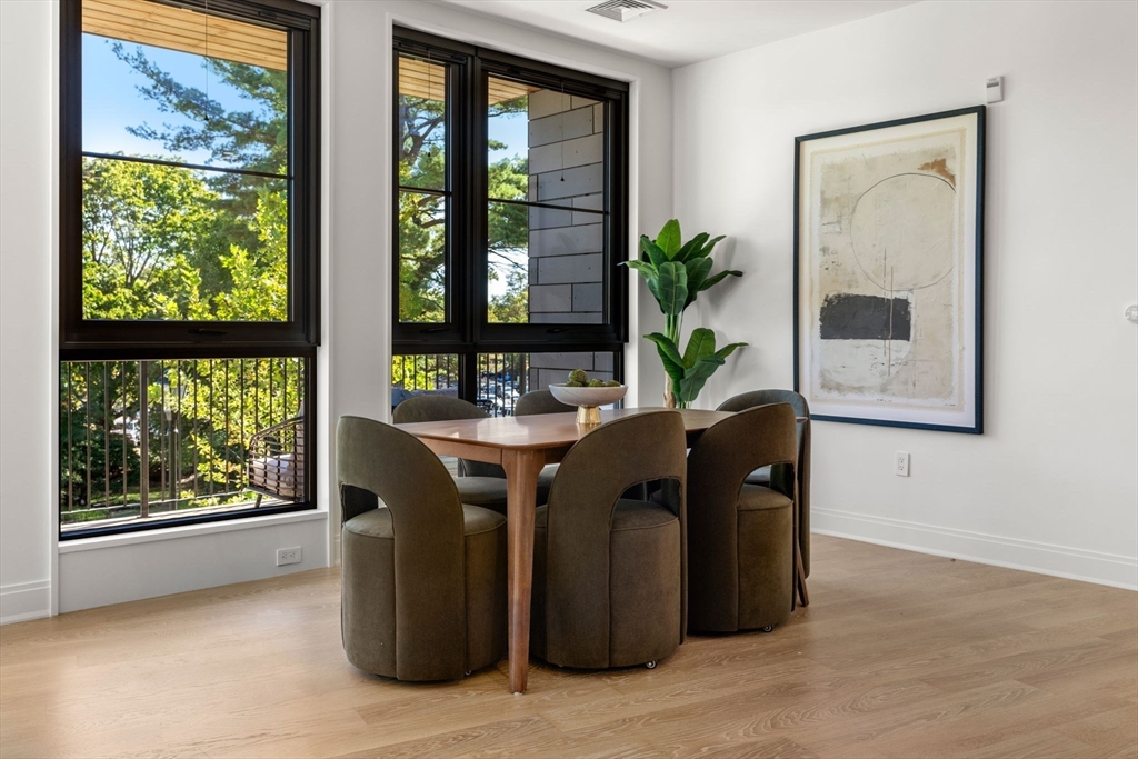 100 Linden Street, Unit 106 Wellesley, MA 02482 - Photo 7 of 28 a living room with large windows and a table