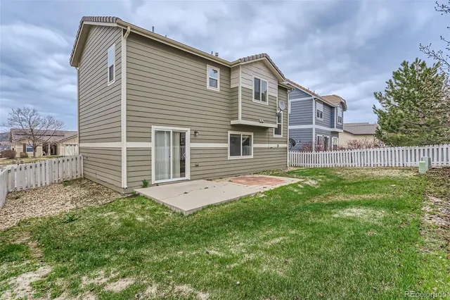 a house with green field in front of it
