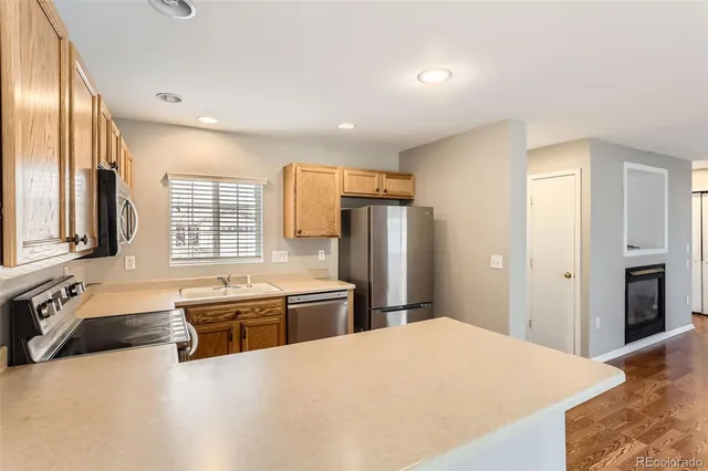 a large kitchen with stainless steel appliances granite countertop a refrigerator and a sink