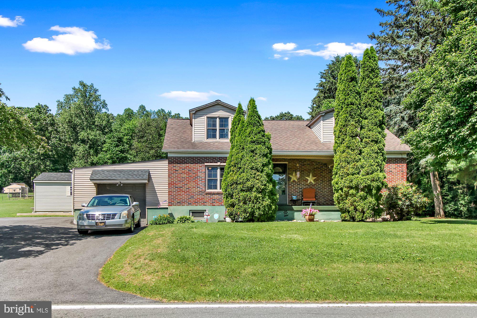 a front view of a house with a garden and yard