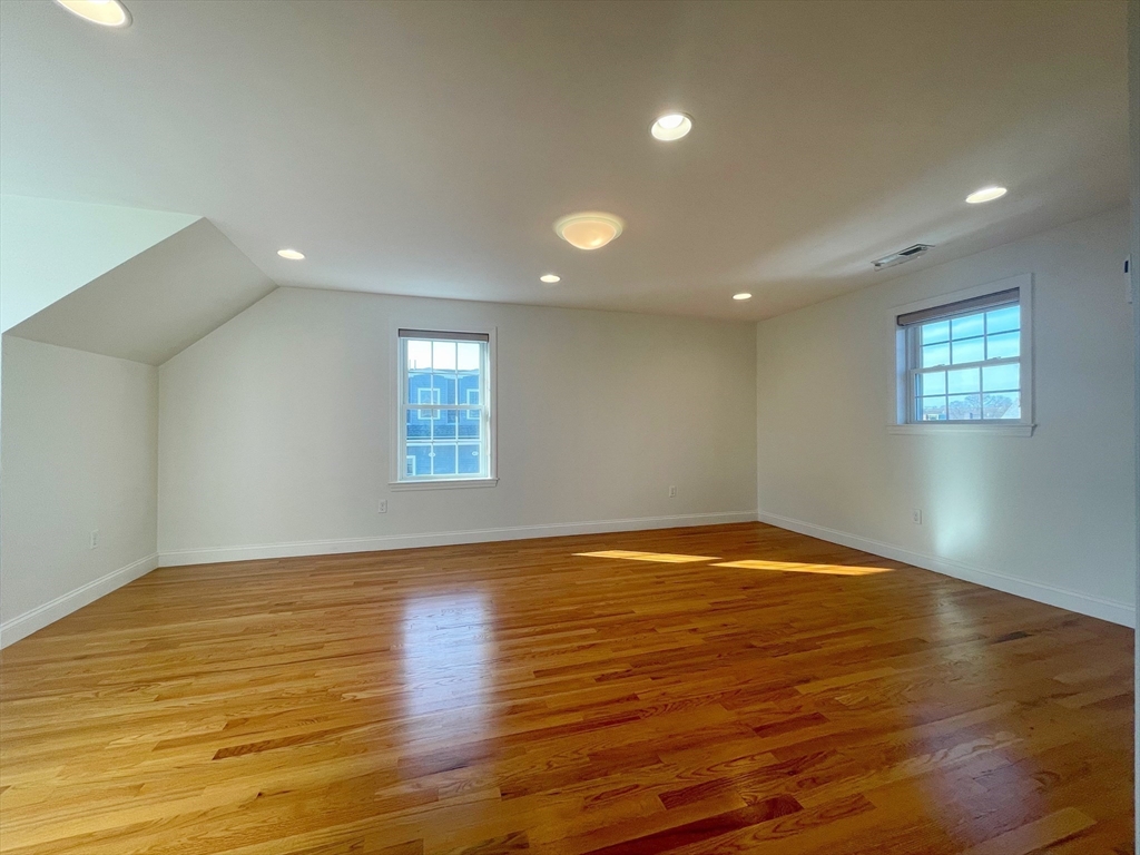 12 Naviens Lane, Unit 1 Waltham, MA 02453 - Photo 6 of 12 a view of an empty room with wooden floor and a window