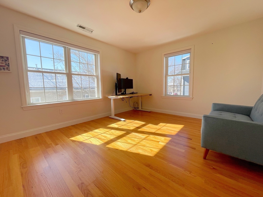 12 Naviens Lane, Unit 1 Waltham, MA 02453 - Photo 10 of 12 a view of an empty room with a window and wooden floor