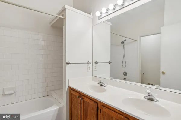 a bathroom with a double vanity sink a large mirror and shower