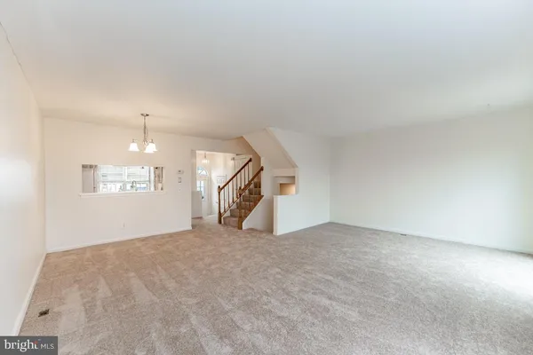 an empty room with a ceiling fan and window