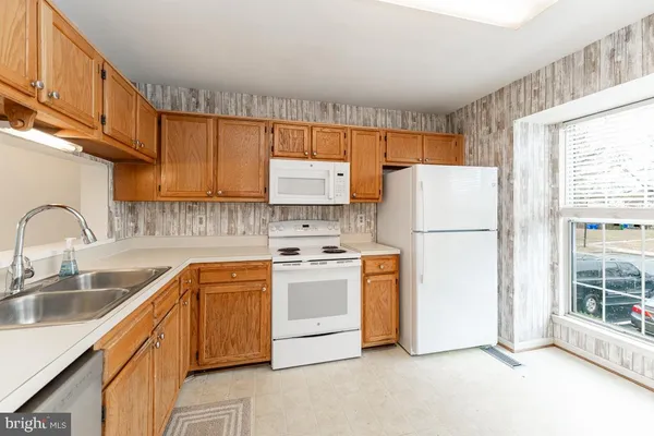 a kitchen with a sink a refrigerator and window
