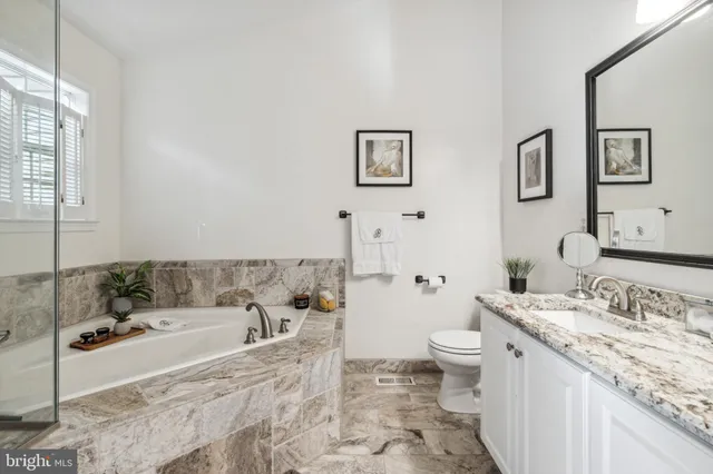 a spacious bathroom with a granite countertop tub sink and mirror