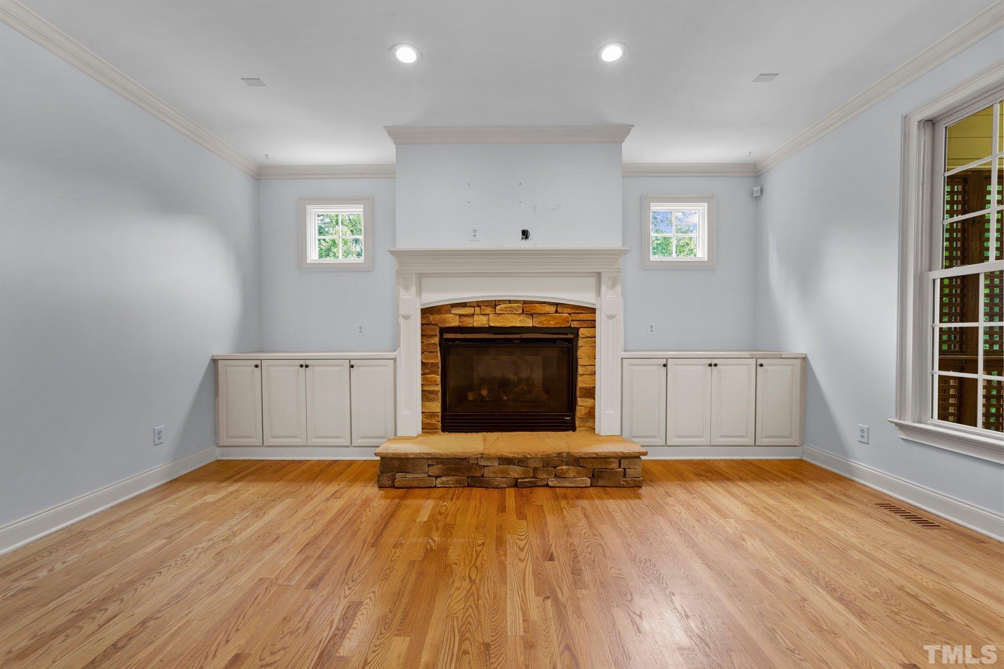 4012 Grandbridge Drive Apex, NC 27539 - Photo 21 of 51 an empty room with windows a fireplace and wooden floor