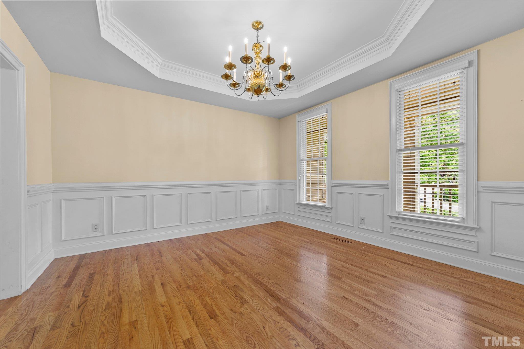 4012 Grandbridge Drive Apex, NC 27539 - Photo 26 of 51 an empty room with wooden floor chandelier and windows