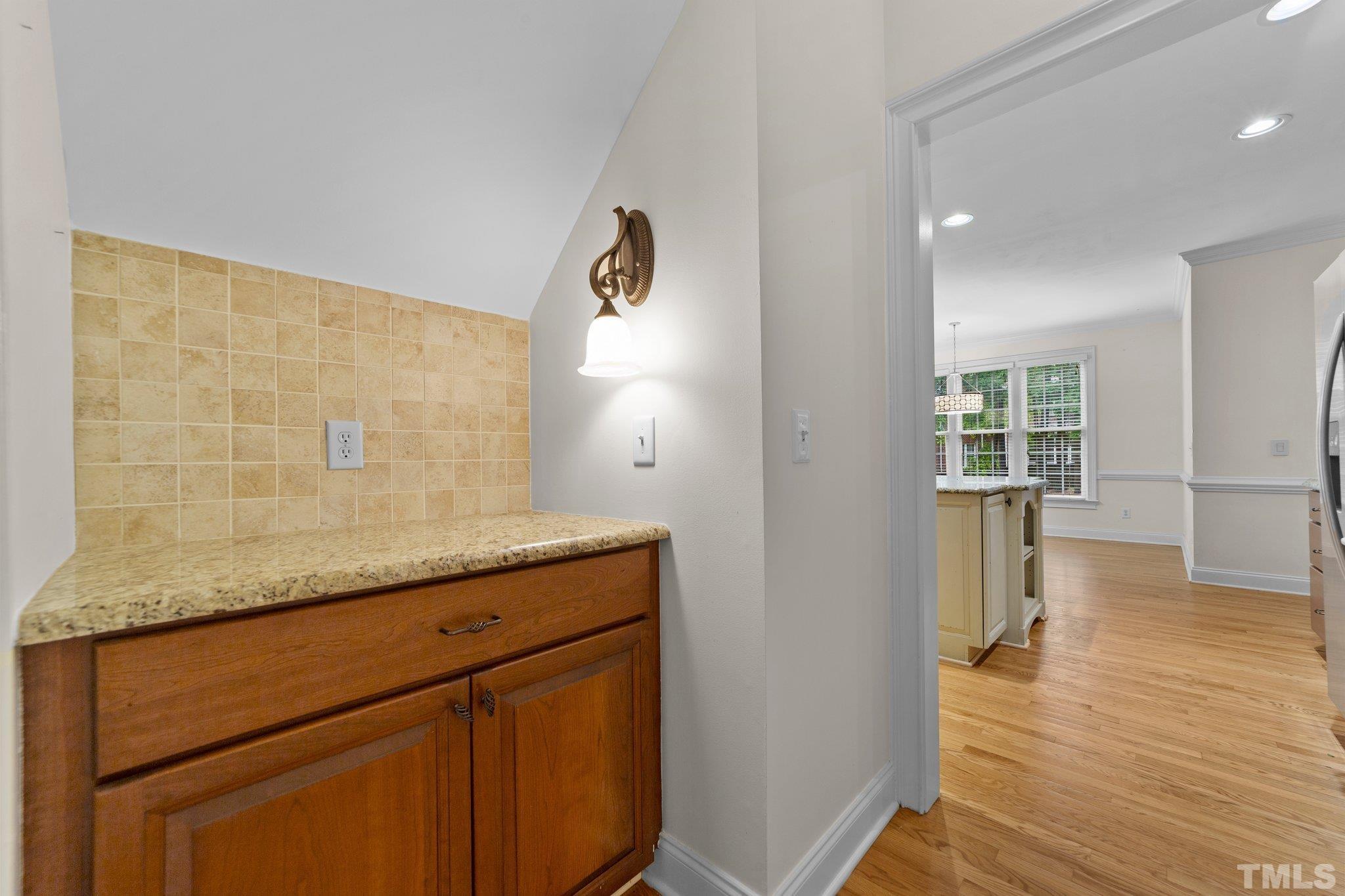 4012 Grandbridge Drive Apex, NC 27539 - Photo 27 of 51 a hallway with granite countertop white cabinets and wooden floor