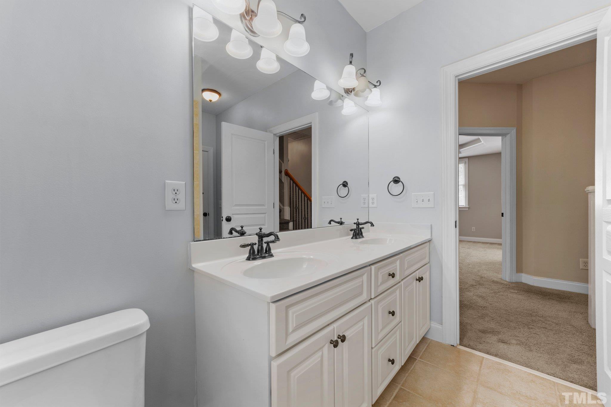 4012 Grandbridge Drive Apex, NC 27539 - Photo 40 of 51 a bathroom with a double vanity sink and a mirror