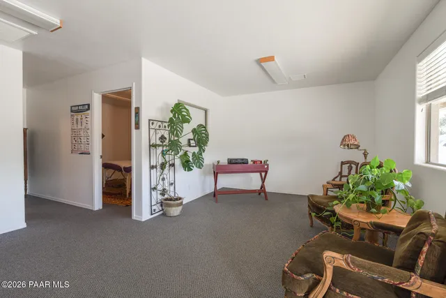 a workspace room with furniture and a potted plant