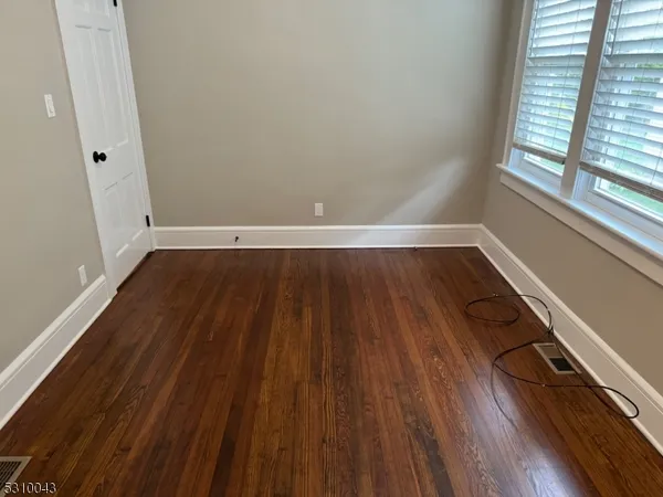 a view of a room with wooden floors and window