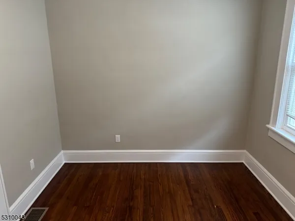 a view of an empty room and wooden floor