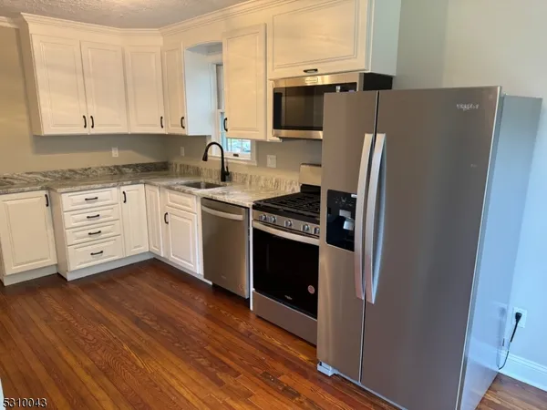 a kitchen with stainless steel appliances a refrigerator sink and microwave
