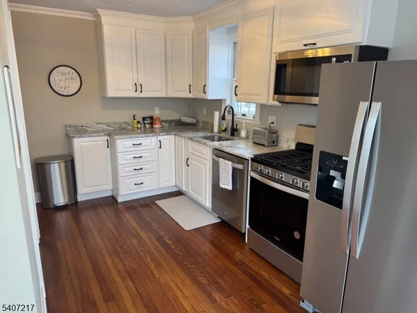 a kitchen with stainless steel appliances a stove a microwave and a refrigerator