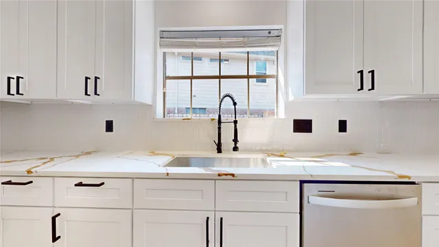 a kitchen with stainless steel appliances white cabinets sink and wooden floor