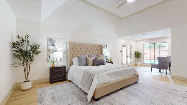 a bedroom with a large bed and a potted plant