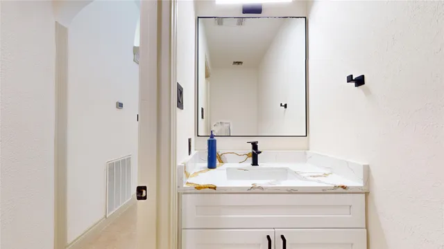 a view of a brick house with large windows and a table and chairs in front of house