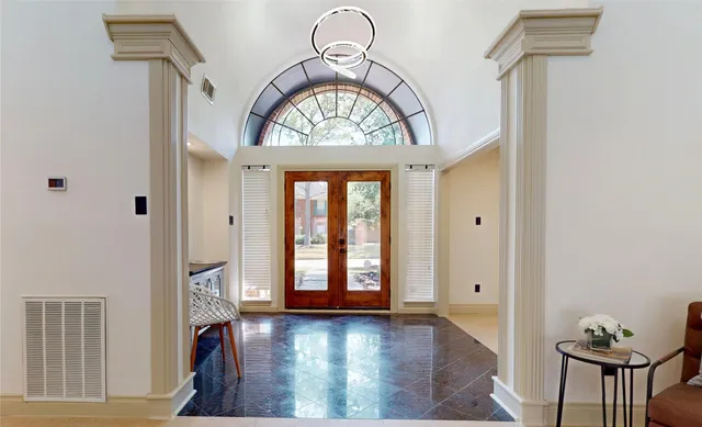 a living room with furniture a chandelier and a mirror