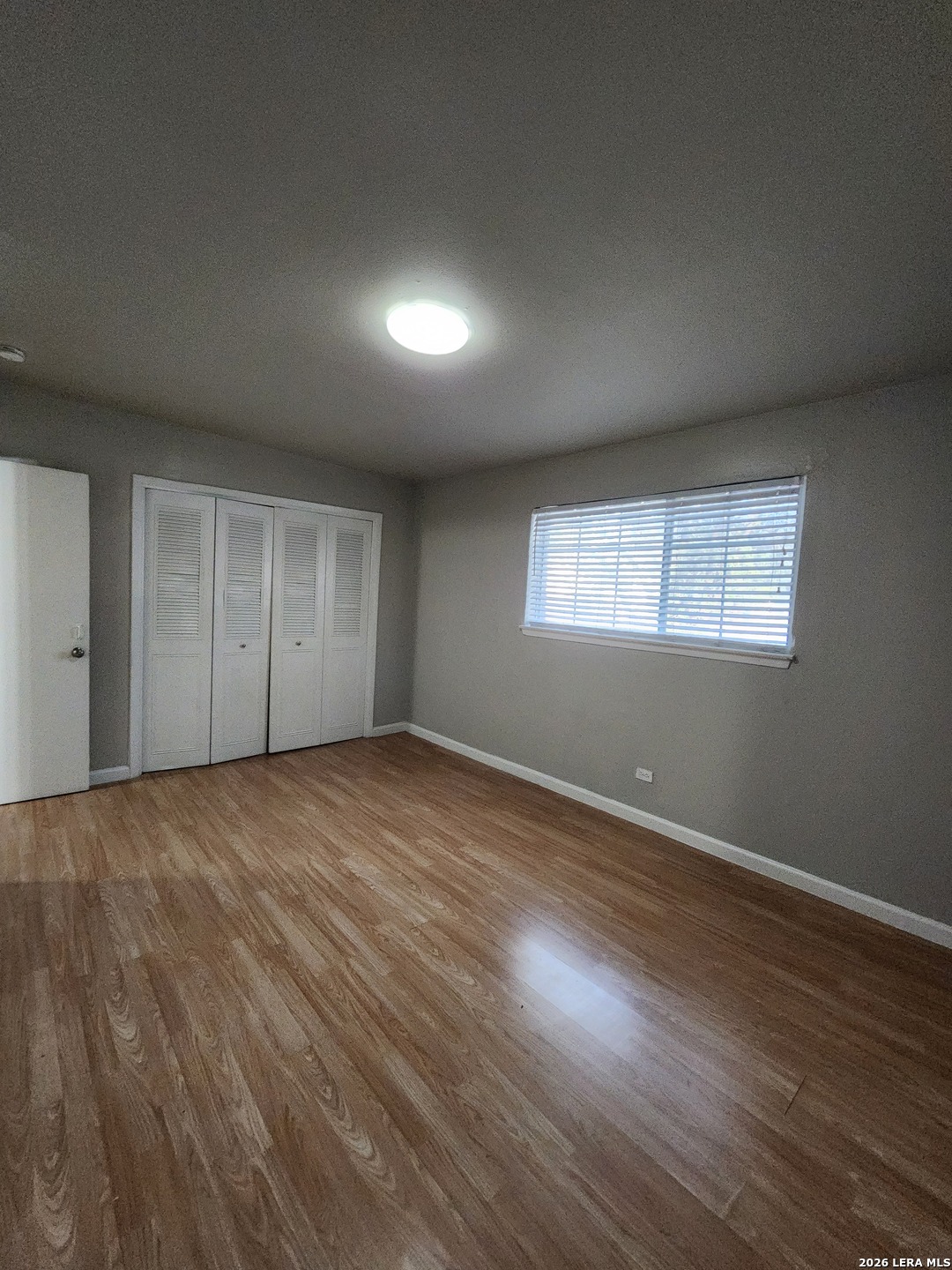 615 Vance Jackson Road, Unit 204 San Antonio, TX 78201 - Photo 11 of 14 an empty room with wooden floor and windows