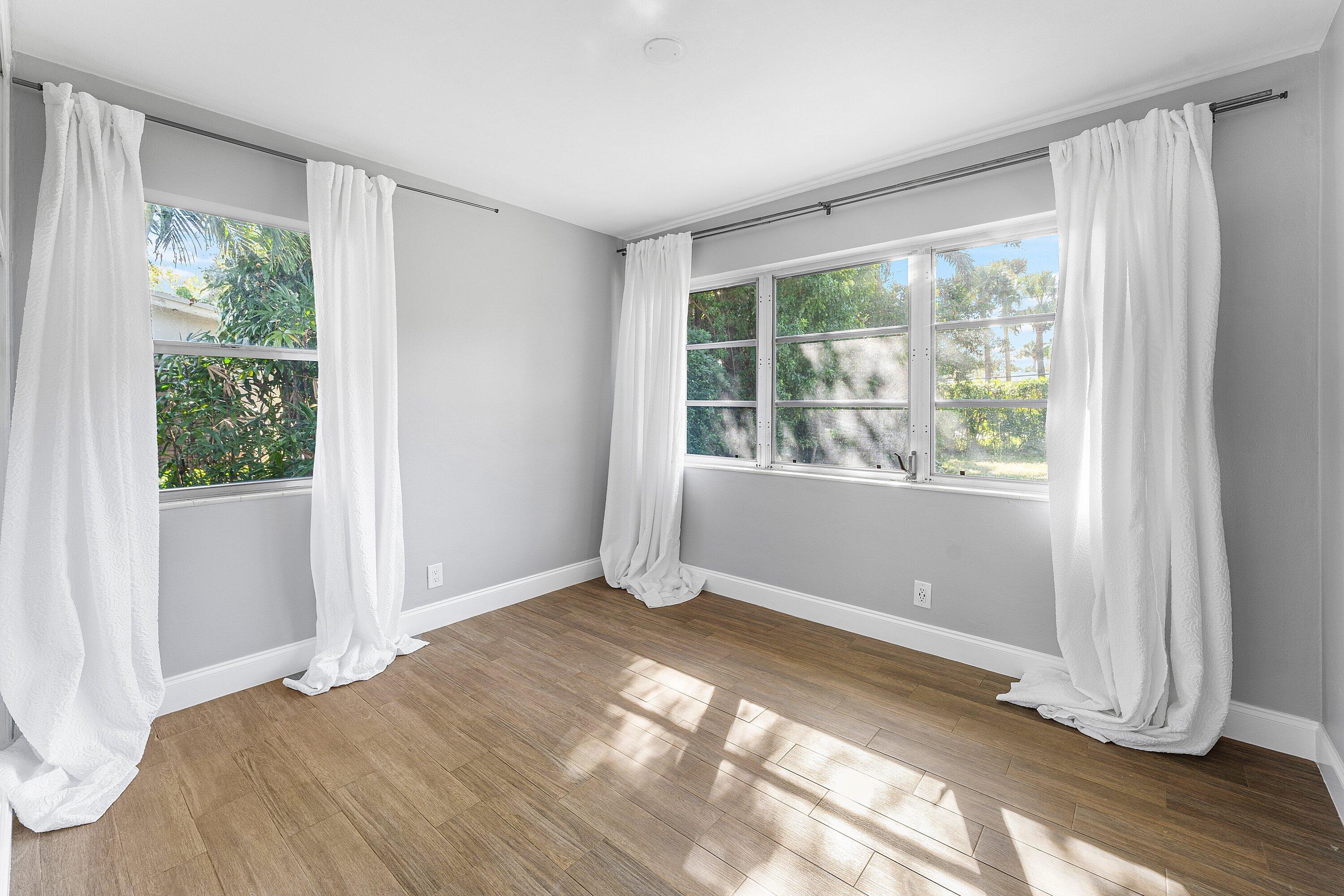 817 Buttonwood Road North Palm Beach, FL 33408 - Photo 16 of 39 a view of an empty room with wooden floor and a window
