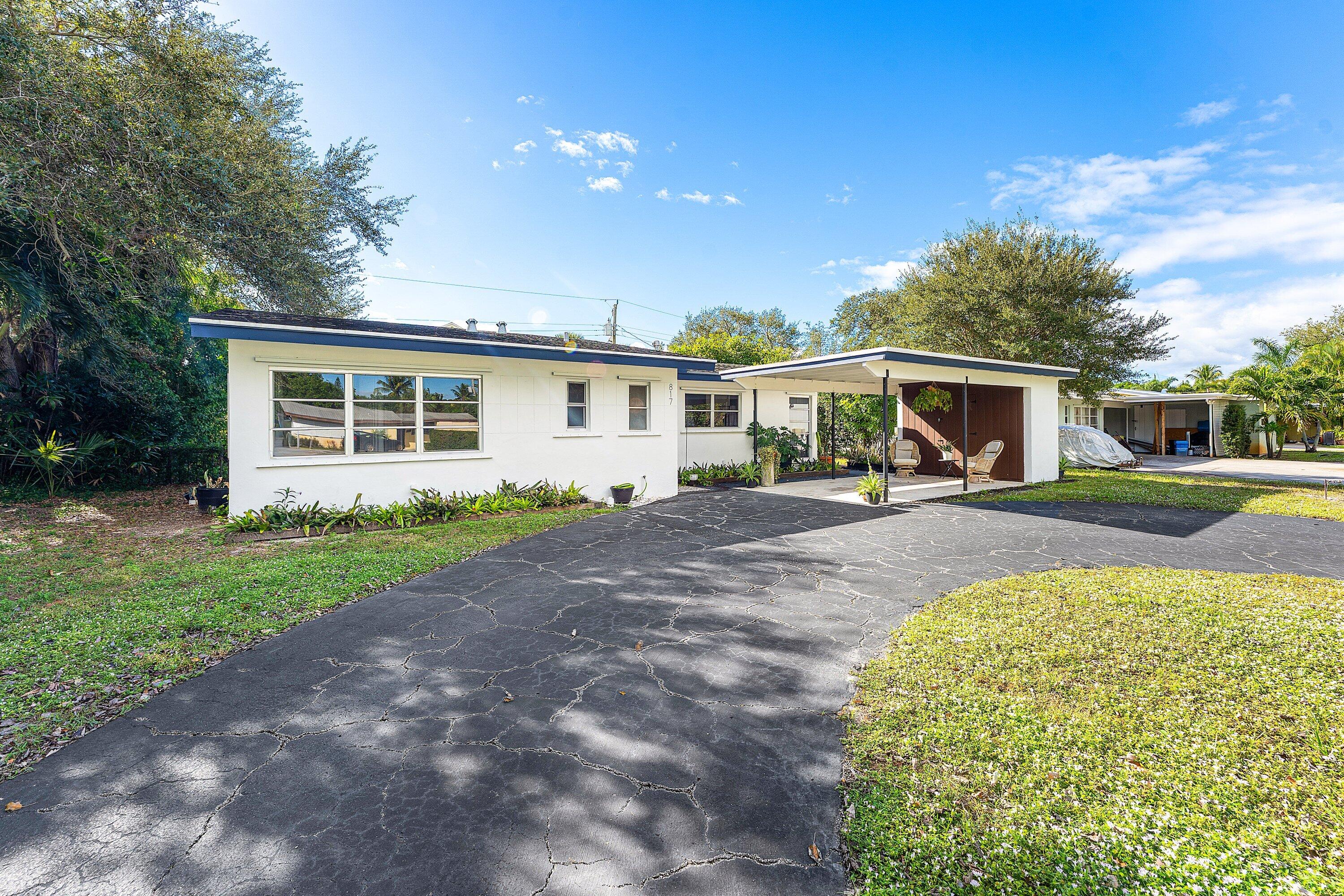 817 Buttonwood Road North Palm Beach, FL 33408 - Photo 28 of 39 a front view of a house with garden