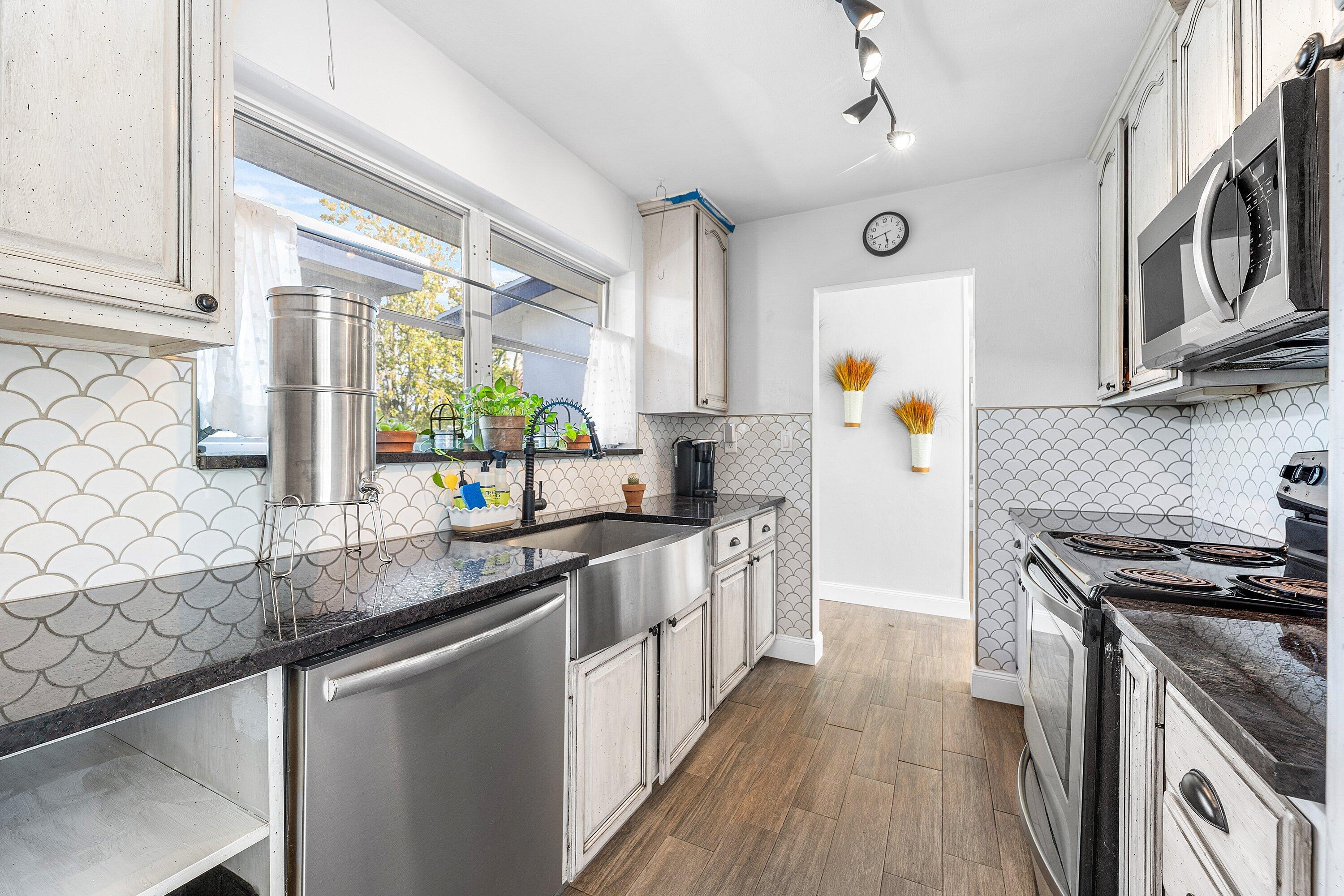 817 Buttonwood Road North Palm Beach, FL 33408 - Photo 9 of 39 a kitchen with stainless steel appliances granite countertop a stove a sink and a refrigerator