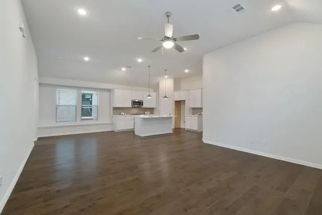 a view of kitchen with wooden floor and a refrigerator