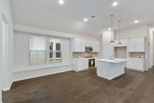 a kitchen with white cabinets and window