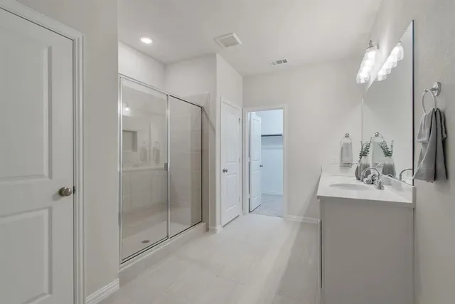 a spacious bathroom with a double vanity sink mirror and shower