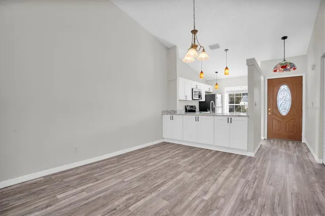 a view of a room with wooden floor and windows