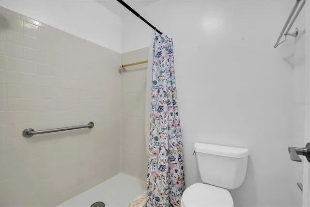 a white toilet sitting next to a shower