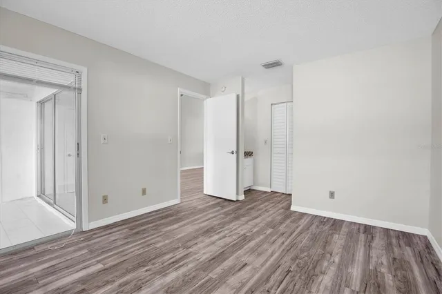 a view of an empty room with wooden floor
